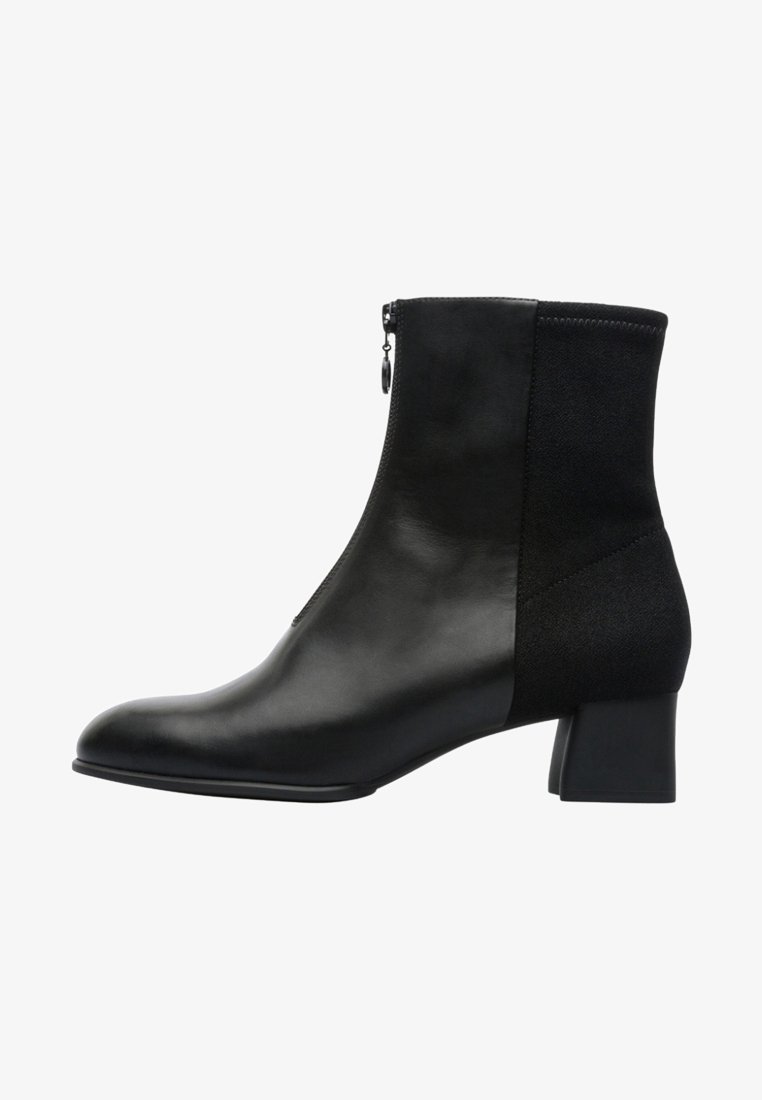 Bottine en cuir noir avec fermeture éclair latérale, talon bloc, devant lisse contrastant avec un panneau arrière texturé.