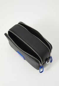 Black leather bag with two zippered compartments, silver hardware, blue accents, and a rectangular shape. Smooth texture with a minimalist design.