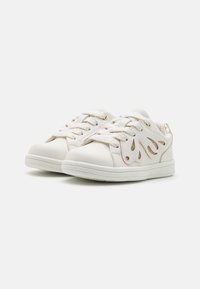 Witte sneakers met een glad leren bovenwerk, voorzien van gouden accenten en uitgesneden vlamontwerpen aan de zijkanten. Vetersluiting en rubberen zolen.