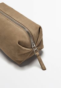Borsa a mano in suede marrone con chiusura a zip, caratterizzata da una texture liscia e una forma rettangolare piatta, accentuata da hardware in metallo argentato.