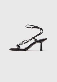 Sandale cu toc înalt din suede negru, cu vârf ascuțit, curea la gleznă și detalii decorative cu studs pe curele.