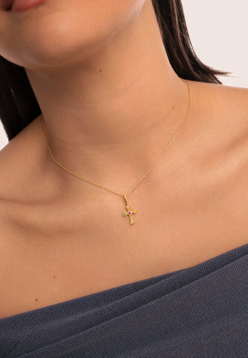 Collar de cadena de oro con un pequeño colgante de cruz decorado con piedras preciosas de colores en tonos rosa, verde y claro.