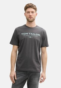 Gray cotton t-shirt featuring a crew neckline and a graphic logo in light blue text on the front. Short sleeves, relaxed fit.