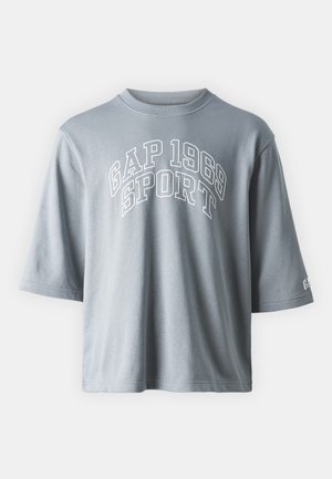 T-shirt de algodão cinza com mangas curtas, um decote redondo e o texto "GAP 1969 SPORT" em letras brancas em negrito na parte da frente.