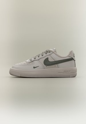 Bielo-sivá teniska Nike Air Force 1 so sivým logom swoosh, šnúrkami a textúrovanou podrážkou, zobrazená z boku na neutrálnom pozadí.