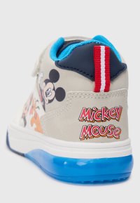 Sapatilhas para rapazes com um upper sintético bege e personagens de desenhos animados; detalhes azuis e aba no calcanhar, sola branca com detalhes azuis, com a marca "Mickey Mouse".