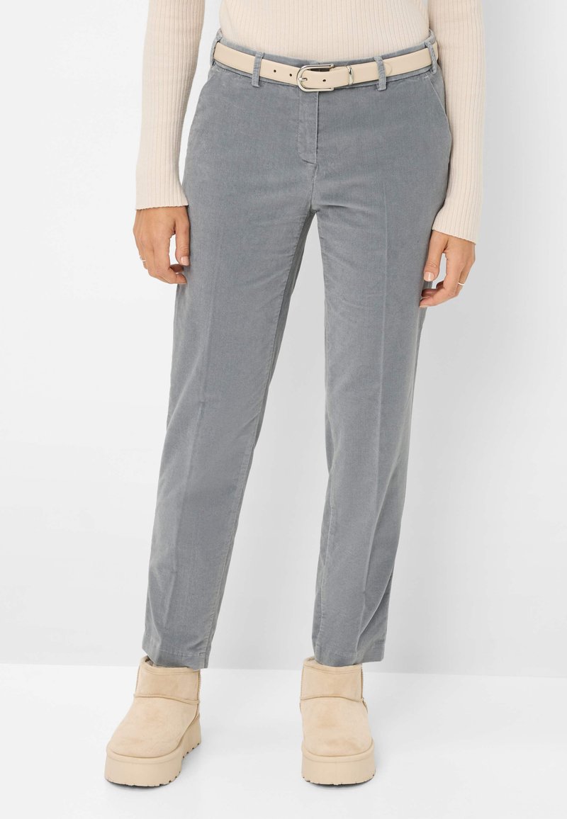Pantalon en velours côtelé gris avec une coupe droite, associé à une ceinture beige et des bottines beige à la cheville, mettant en valeur une texture douce et des détails subtils.