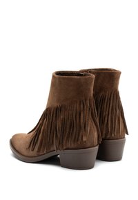 Stivaletti in suede marrone con dettagli in frange, tacco medio, punta rotonda e chiusura con zip laterale. Texture liscia e costruzione robusta.