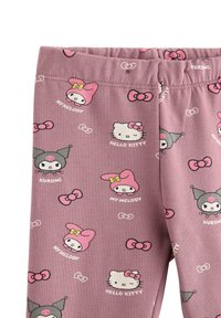 Rosa leggings i mjukt tyg, med upprepade tryck av tecknade figurer som Hello Kitty och My Melody, samt med rosetter.