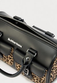 Black leather handbag with leopard print accents, silver hardware, and zip closure; features structured shape and detachable strap.