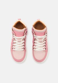 Des chaussures montantes roses en cuir perforé, avec des accents contrastants de rose clair, des lacets blancs et une doublure intérieure beige. Fermeture éclair sur le côté.