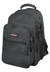 Mochila de tela negra con múltiples compartimentos, cremalleras, bolsillo de malla en el lateral y un asa acolchada. Presenta el logo de Eastpak en la parte frontal.