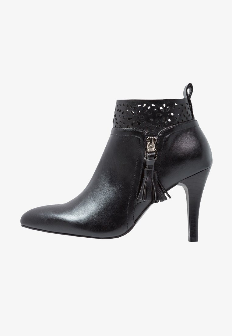 Bottine en cuir noir avec talon haut, motif floral découpé sur le revers, fermeture éclair latérale et détail pompon.