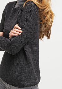 Maglione lavorato a maglia grigio scuro con colletto tondo, tessuto strutturato, vestibilità rilassata e cuciture delle spalle scese. Design senza cuciture con una finitura morbida.