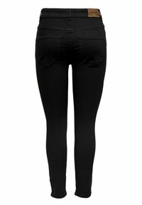 Jeans ajustados de cintura alta negros mostrados desde atrás, con dos bolsillos traseros y una etiqueta de marca marrón en la cinturilla.