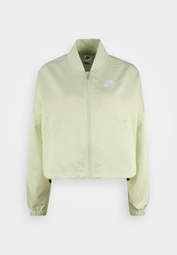 Korsad ljusgrön Nike-jacka med dragkedja framtill, elastiska muddar, sidofickor och en vit logotyp på bröstet. Mjuk, lätt tyg.