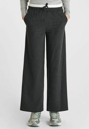 Wide-leg, pinstriped black pants with an elastic waistband and drawstring. Made of lightweight fabric, featuring side pockets.