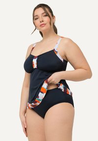 Tankini de natation bleu marine avec des bretelles à motifs comportant des accents orange, vert et rouge, associé à un bas de bikini bleu marine assorti. Texture lisse.