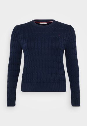 Tumši zila adīta džemperi ar tekstūru vītnes rakstu, apaļu kakla izgriezumu un ribotām piedurknēm un apakšmalu. Ir neliels logo uz krūtīm.