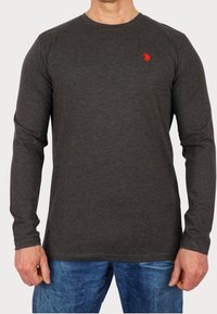 Ciemnoszara koszulka z długim rękawem, wykonana z miękkiego materiału, z małym czerwonym logo polo na piersi, zaokrąglonym dekoltem i standardowym krojem.