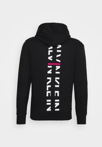 Sudadera negra con un logotipo vertical "CALVIN KLEIN" en blanco y un acento rosa. Material suave, bolsillo tipo canguro y capucha con cordón.