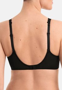 Reggiseno wireless nero con una texture liscia e opaca, design a schiena bassa, spalline adjustable e delicati dettagli in pizzo sulle spalline.