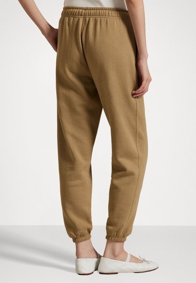 Braune, schmal zulaufende Jogginghosen aus weichem Stoff mit einem elastischen Bund und Bündchen. Das Design zeichnet sich durch eine glatte Textur und eine lockere Passform aus.