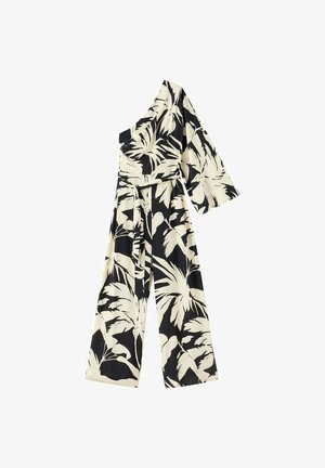 Combinaison noire asymétrique à une épaule avec jambes larges et imprimé feuilles tropicales crème, comprenant une ceinture et une manche évasée unique.