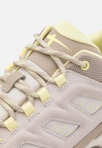 Lightweight sneakers featuring a soft, beige suede upper, mesh details, yellow accents, and textured laces with a secure fit design.