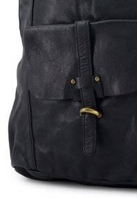 Black leather backpack featuring a textured surface, two front pockets, a leather strap with brass hardware, and a minimalist design.