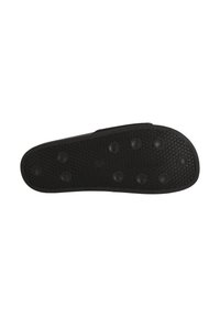 Black rubber shoe sole with a textured surface and circular studs for grip, featuring a smooth edge and a rounded shape.