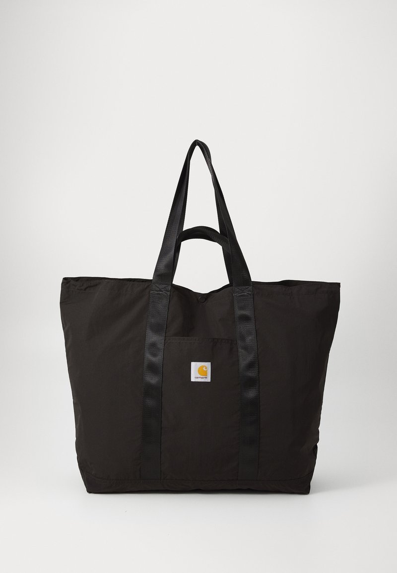 Sac cabas Carhartt noir avec longues anses, poche avant et écusson logo sur un fond clair uni.