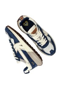 Sneaker caratterizzate da un mix di suede blu navy e materiali sintetici crema, con un design texturizzato, suola in gomma scura e grafica a occhio sulla soletta.