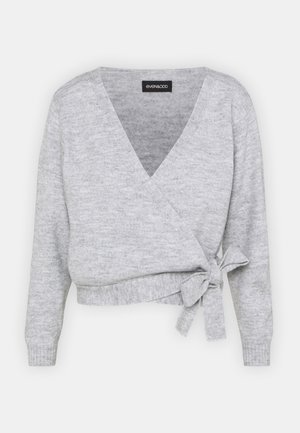 Pull en maille gris clair style cache-cœur avec manches longues et un nœud noué sur le côté, longueur raccourcie, tissu doux et texturé.