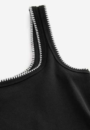 Zwart geribd tanktop met zilveren stiksel langs de zomen, die de halslijn en armsgaten accentueren. Soepele textuur en aansluitend ontwerp.
