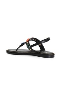 Musta nahkainen thong-sandaali, jossa on pyöreät kivikoristeet punaisena, sinisenä ja vihreänä. Sandaalissa on kapea remmi ja tasapohja, jossa on kultainen reunus.