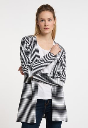 Cardigan a righe blu navy e bianche, realizzato in tessuto morbido, con apertura frontale, maniche lunghe, che arriva a metà coscia, abbinato a una maglietta bianca.
