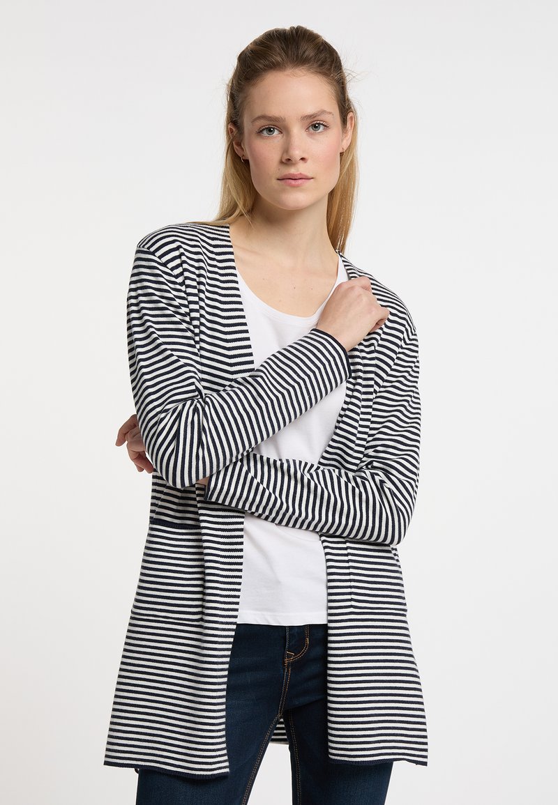 Randig kardiagan i marinblått och vitt, tillverkad av mjukt tyg, öppet fram, långa ärmar, sträckande till mitten av låret, tillsammans med en vit T-shirt.