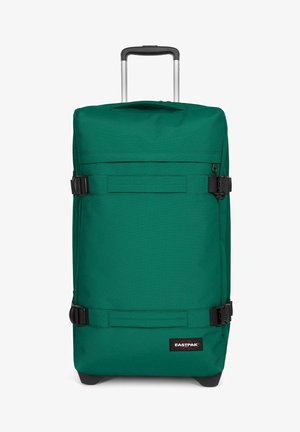 Maleta suave verde con ruedas, mango telescópico, correas de compresión laterales y parche con el logo de Eastpak en la parte inferior delantera.