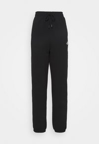 Schwarze Jogginghose aus weichem Stoff, mit elastischem Bund und Kordelzug, sowie Bündchen an den Knöcheln. Minimale Markenkennzeichnung an der Seite.