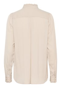 Blusa beige a maniche lunghe con colletto arricciato, spalle plissettate e polsini con bottoni. Tessuto morbido e leggero con un design semplice.