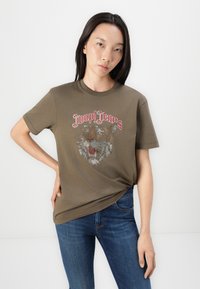 Oliven grønn bomull t-skjorte med et tiger-design i rhinstein og "Joop! Jeans"-tekst over. Korte ermer og avslappet passform.
