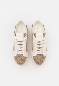Sneaker con tomaia in tessuto beige caratterizzata da un sottile motivo a logo, chiusura con lacci bianchi e suola in gomma testurizzata.