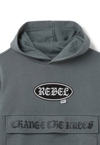 Grauer Kapuzenpullover mit aufgesticktem "REBEL"-Patch und dem Schriftzug "CHANGE THE RULES". Hergestellt aus weichem Material, lässiger Kragen und Fronttasche.