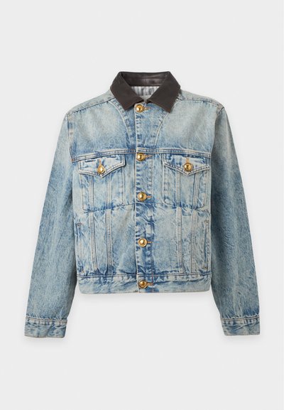 Veste en jean bleu clair avec boutons dorés, deux poches poitrine à rabat, coutures verticales et col marron foncé contrasté.