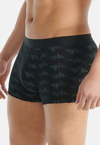 Černé boxerky s geometrickým vzorem v tmavých odstínech, s hladkým pasem a přiléhavým střihem pro pohodlí a podporu.