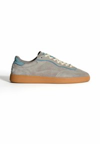 Sneaker in suede grigia con dettagli blu, lacci bianchi e suola in gomma naturale, mostrata di lato su uno sfondo bianco.