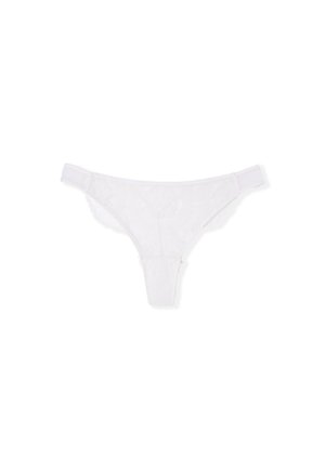 White lace thong featuring a floral pattern, thin elastic waistband, and minimal coverage. Textured lace with a scalloped edge detail.