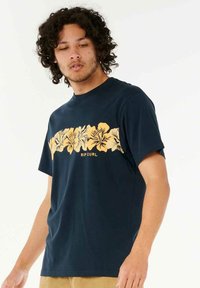 Dunkelblaues T-Shirt aus Baumwolle mit einem floralen gelben Grafikdesign und dem Text "RIP CURL" in der Mitte. Kurzärmlig und Rundhalsausschnitt.