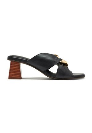 Sandales glissantes en cuir noir avec un bout ouvert, présentant un détail noué, un accent doré et un talon en bois effilé.